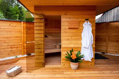 a wooden sauna with a white dress hanging on the wall at House 