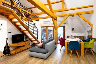 a living room with a staircase and a table and chairs at House 