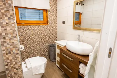a bathroom with a sink and a toilet and a mirror at House 