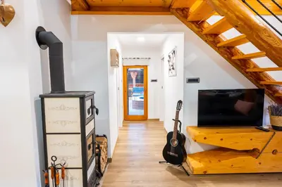 a living room with a wood stove and a guitar at House 