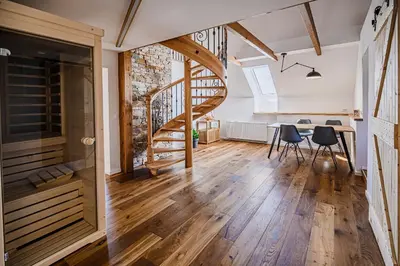 a room with a staircase and a table and chairs at Mountain View Apartment with Sauna in Cerklje na Gorenjskem