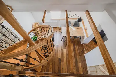a spiral staircase in a house with wooden floors at Mountain View Apartment with Sauna in Cerklje na Gorenjskem