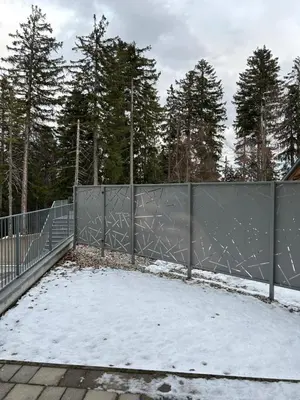 a fence in the snow with trees in the background at Pohorske terase Gabi in Pohorje