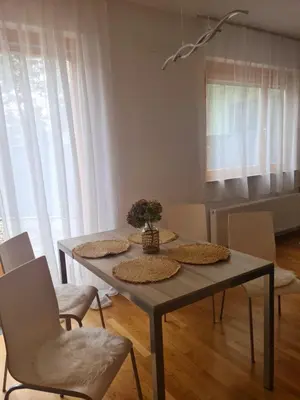 a dining table and chairs in a living room at Pohorske terase Gabi in Pohorje