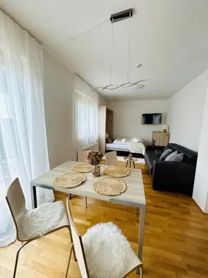 a living room with a table and chairs and a couch at Pohorske terase Gabi in Pohorje
