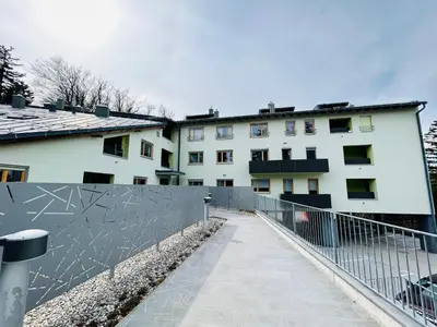 a fence in front of a white building at Pohorske terase Gabi in Pohorje