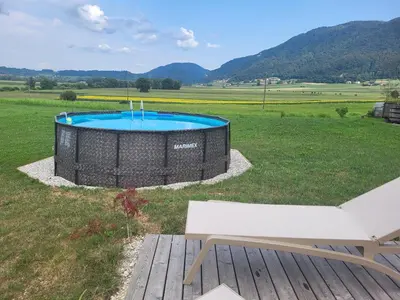 a pool in the middle of a field with a bench at WINERY AND APARTMENTS MAROF in Bistrica ob Sotli
