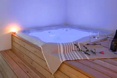 a jacuzzi tub in a room with a candle at WINERY AND APARTMENTS MAROF in Bistrica ob Sotli
