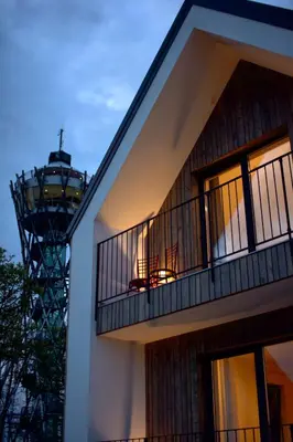 a building with a balcony with a lighthouse in the background at Hiša ob stolpu in Lendava