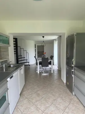 a kitchen and dining room with a table and refrigerator at Apartman Slivnica pri Mariboru in Slivnica pri Mariboru