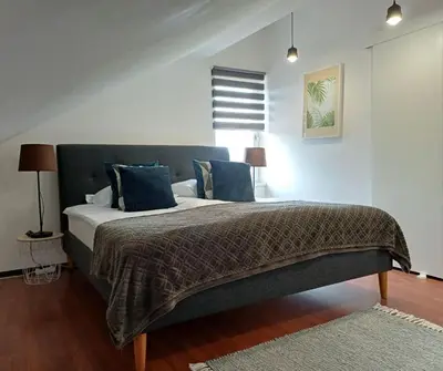 a bedroom with a large bed with blue pillows at Apartman Slivnica pri Mariboru in Slivnica pri Mariboru