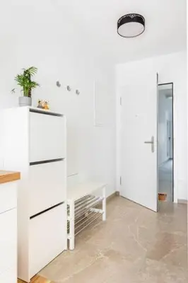 a white kitchen with a potted plant on a counter at LA Studio in Maribor