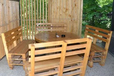a wooden table and chairs in a gazebo at Metkina Hiška -samooskrbna in Topovlje