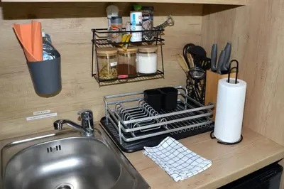a kitchen counter with a sink and a dish drying rack at Metkina Hiška -samooskrbna in Topovlje