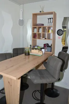 a wooden table with chairs in a room at Metkina Hiška -samooskrbna in Topovlje