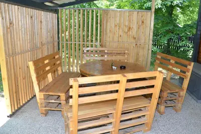 a wooden table and chairs on a patio at Metkina Hiška -samooskrbna in Topovlje