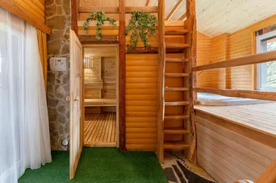 a room with a spiral staircase in a log cabin at Goričko Relax House in Kuzma