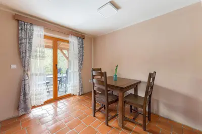 a dining room with a wooden table and chairs at Goričko Relax House in Kuzma