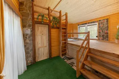 a room with a bunk bed and stairs in a cabin at Goričko Relax House in Kuzma