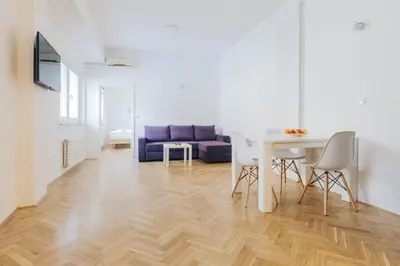 a living room with a table and a blue couch at Apartment Center - Kersnikova in Ljubljana