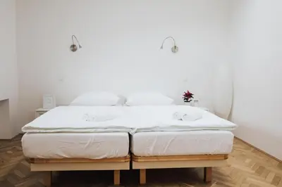 two twin beds in a room with white walls at Apartment Center - Kersnikova in Ljubljana