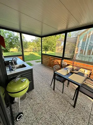 a screened in porch with a sink and a table at BB HOUSE KOLPA RIVERSIDE in Metlika