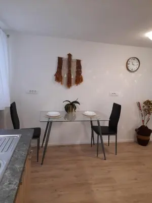 a dining room with a table and chairs and a clock at Studio Eržen in Zgornje Gorje