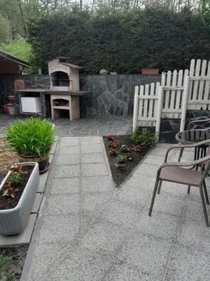 a patio with two white chairs and a grill at Studio Eržen in Zgornje Gorje