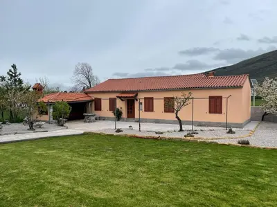 a house with a green lawn in front of it at Hiša Pod Slavnikom in Podgorje
