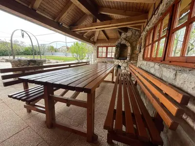 a wooden picnic table and benches in a building at Hiša Pod Slavnikom in Podgorje