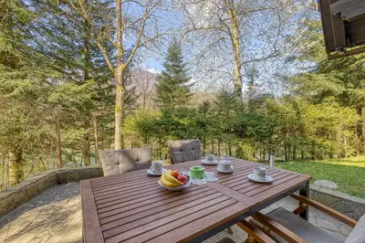 a wooden table with a bowl of fruit on it at Fani's Riverside Cottage - Happy Rentals in Kostel
