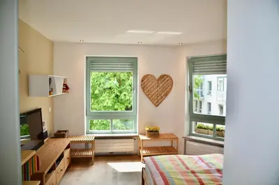 a bedroom with two windows and a heart on the wall at i Design 9 in Ljubljana