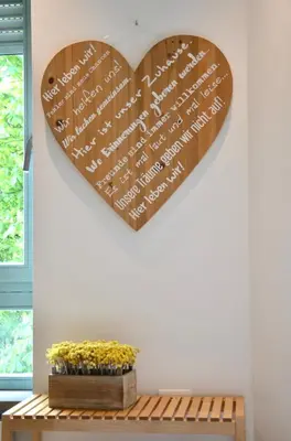 a heart sign hanging on a wall next to a bench at i Design 9 in Ljubljana