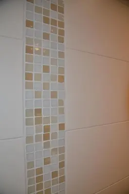 a bathroom with a shower with brown and white tiles at i Design 9 in Ljubljana