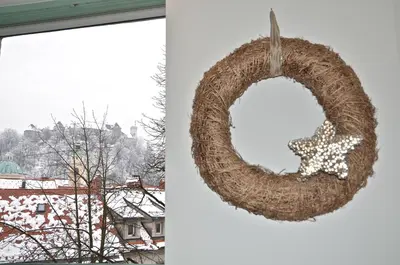 a wreath with a christmas star on it next to a window at i Design 9 in Ljubljana