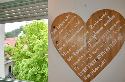 a heart sign hanging on a wall next to a window at i Design 9 in Ljubljana
