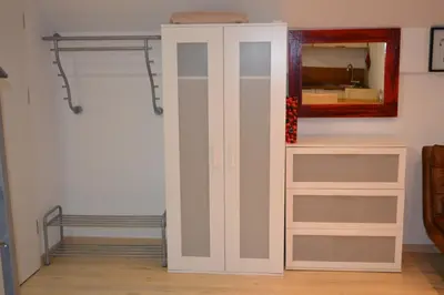 a closet with a white cabinet and a mirror at Petra Garden apartment in Bled