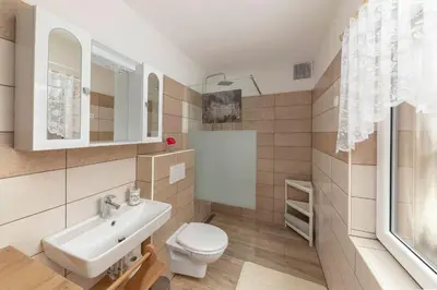 a bathroom with a white toilet and a sink at Počitniška Hiša Pr Martinovih in Postojna