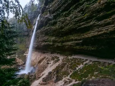 a waterfall on the side of a mountain at A Cottage in the Alps for hiking, cycling, skiing in Jesenice