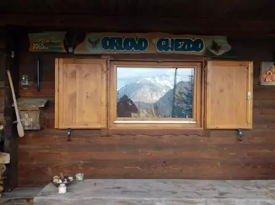 a window in a room with a view of a mountain at A Cottage in the Alps for hiking, cycling, skiing in Jesenice