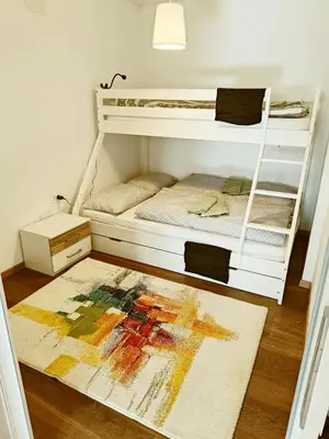 a room with two bunk beds with a rug on the floor at Green Apartment Cerknica in Cerknica