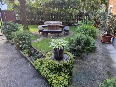 a garden with a table and benches and plants at Blacksmith in Kropa