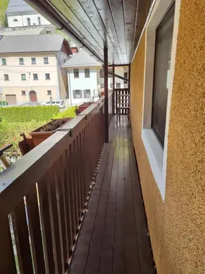 a balcony with a wooden floor and a building at Blacksmith in Kropa