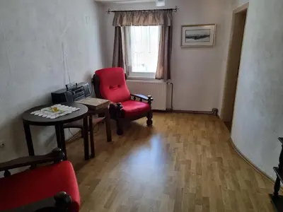 a living room with a red chair and a table at Blacksmith in Kropa