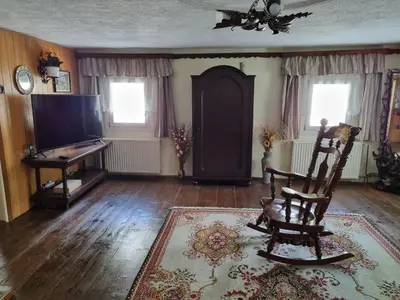 a living room with a chair and a television at Blacksmith in Kropa