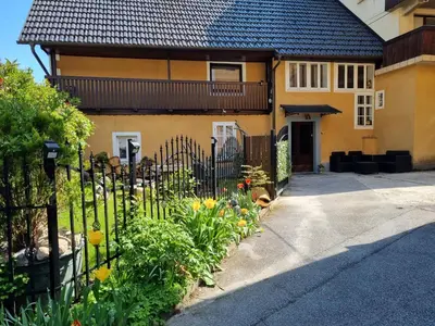 a fence in front of a house with flowers at Blacksmith in Kropa