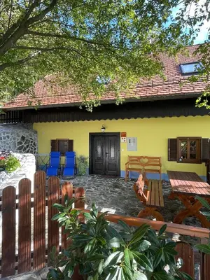 a yellow house with a patio in front of it at Boutique Farm Hrovat in Frankolovo
