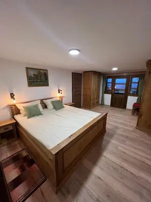 a bedroom with a large bed in a room with wooden floors at Boutique Farm Hrovat in Frankolovo
