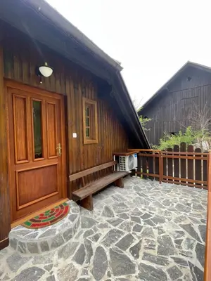 a wooden building with a bench on a patio at Boutique Farm Hrovat in Frankolovo