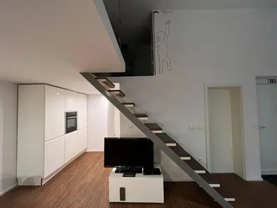 a living room with a staircase and a tv at Absolutum Apartments in Ljubljana